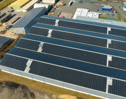 aerial-view-blue-photovoltaic-solar-panels-mounted-industrial-building-roof-producing-green-ecological-electricity-production